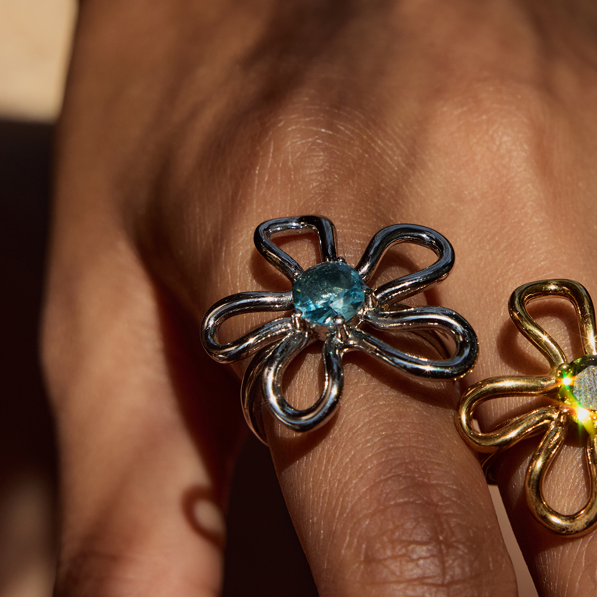 ELENYS Azure Bloom – detail stříbrného prstenu se světle modrým zirkonem na ruce